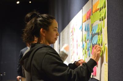 woman writing on post-it note