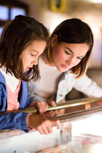 girl with mom looking at glass case